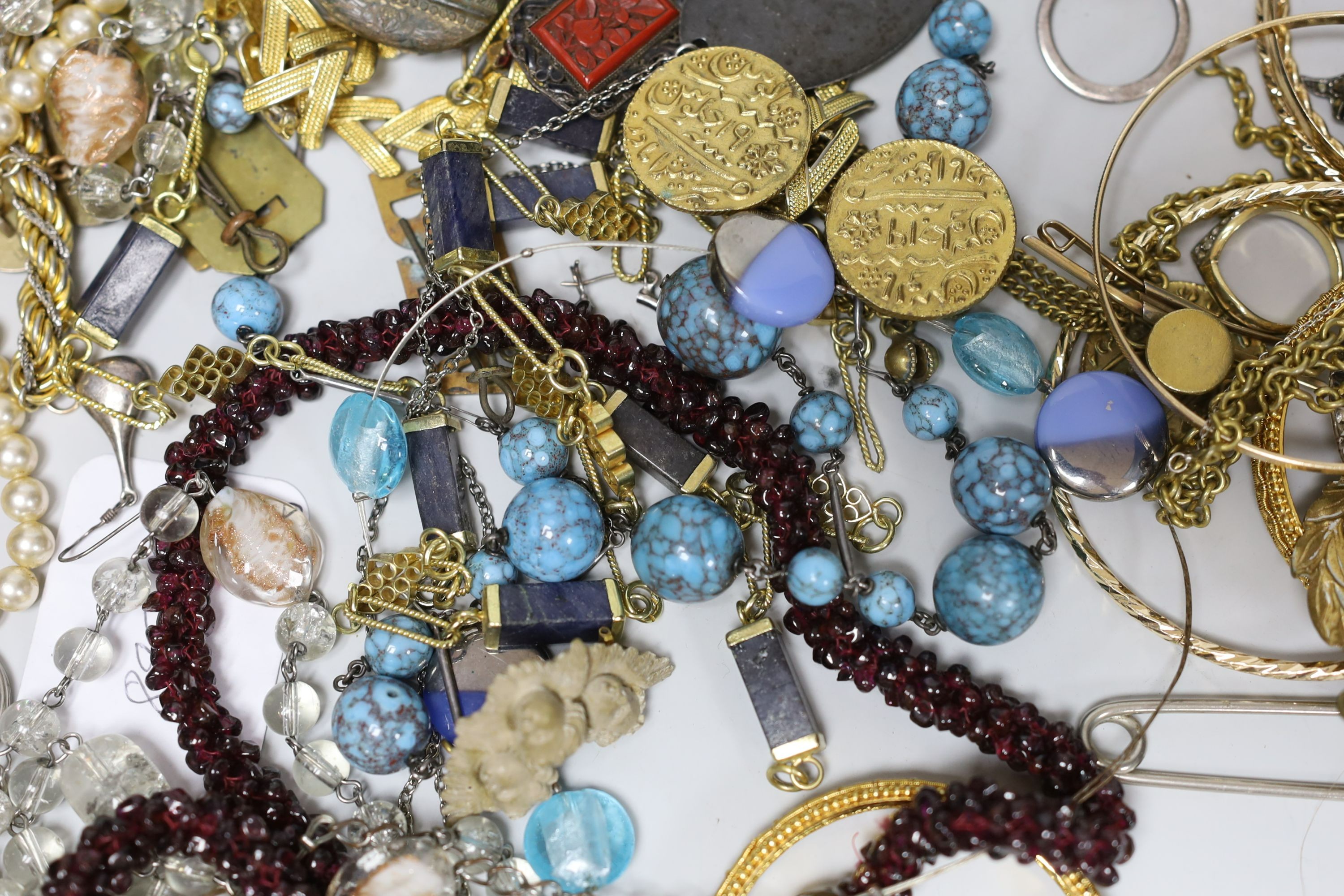 A quantity of assorted costume jewellery and other items including silver and enamel plaque and a garnet bead necklace.